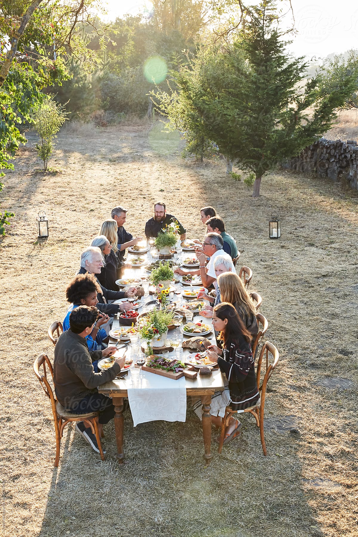 Outdoor dinner party with family and friends at sunset
