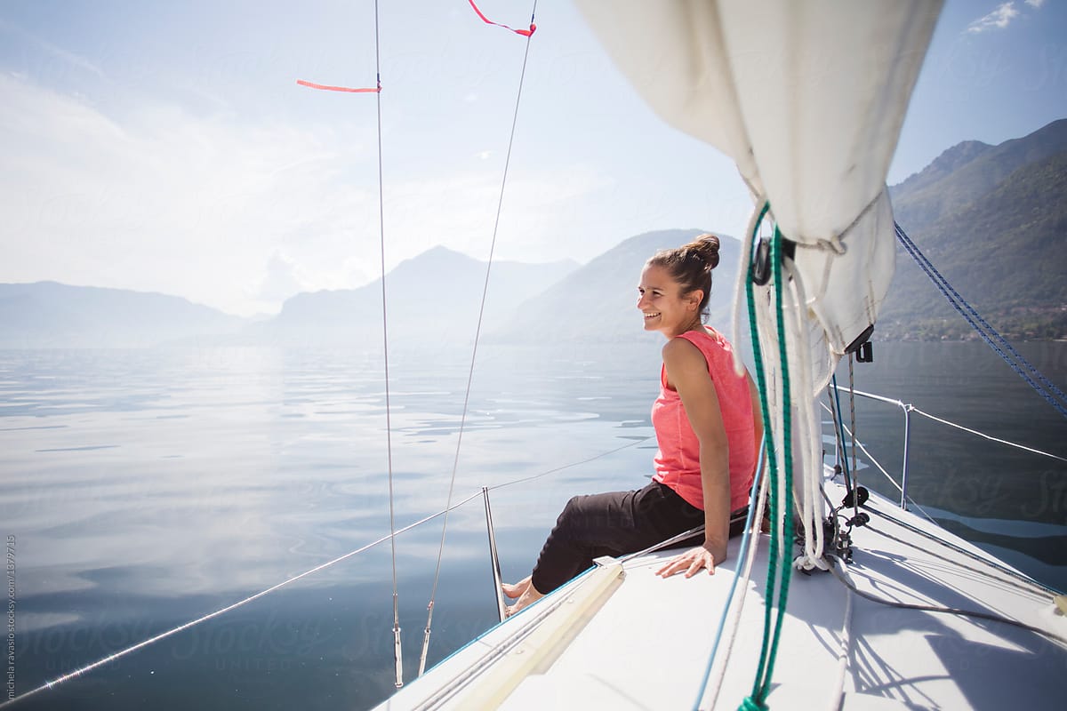 Happy woman looks at the landscape from the sail boat