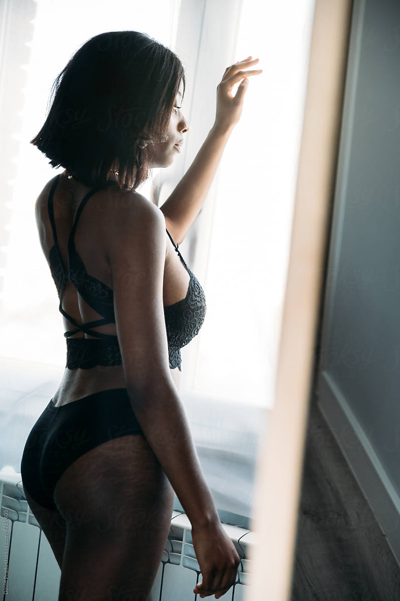 Black Woman In Underwear Standing Near Mirror by Stocksy