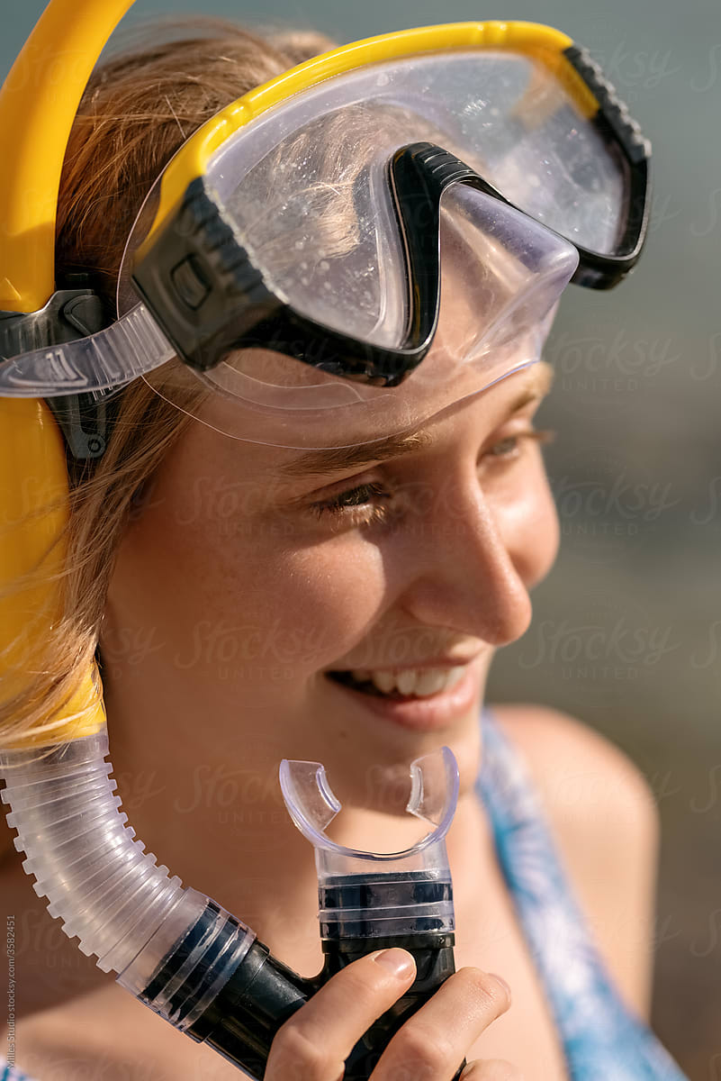 Cheerful young woman with snorkel and goggles