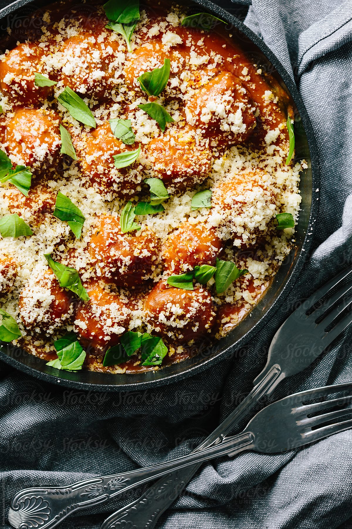 Italian baked meatballs in pan with cheese and basil