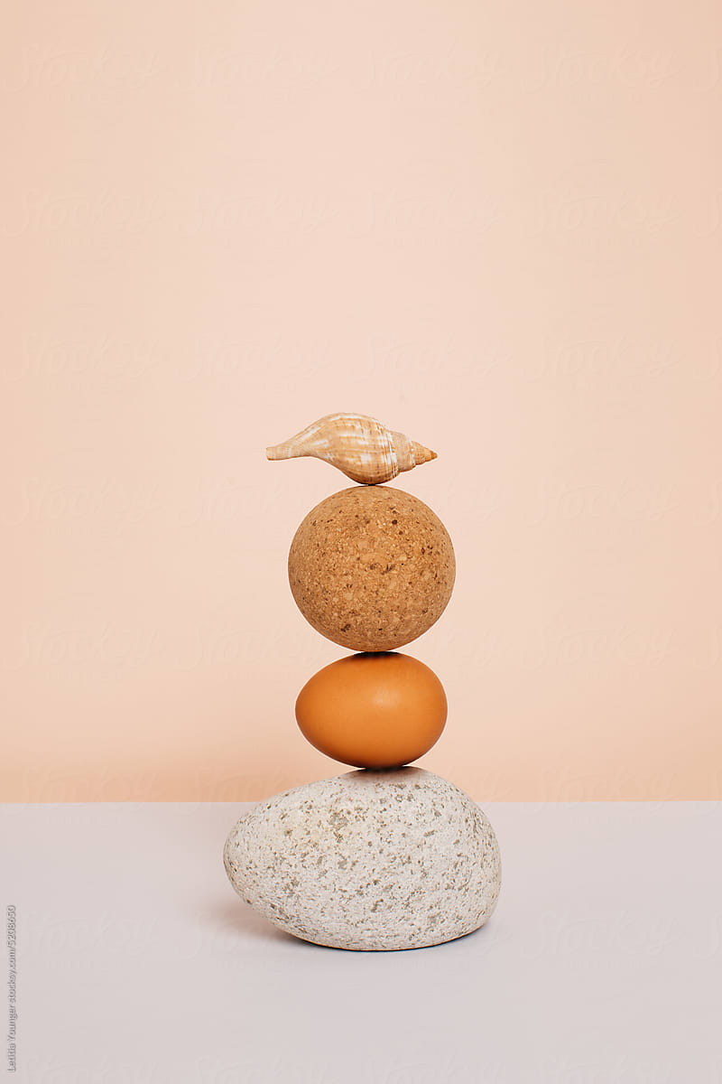 Stone, egg, ball and shell stacked still life