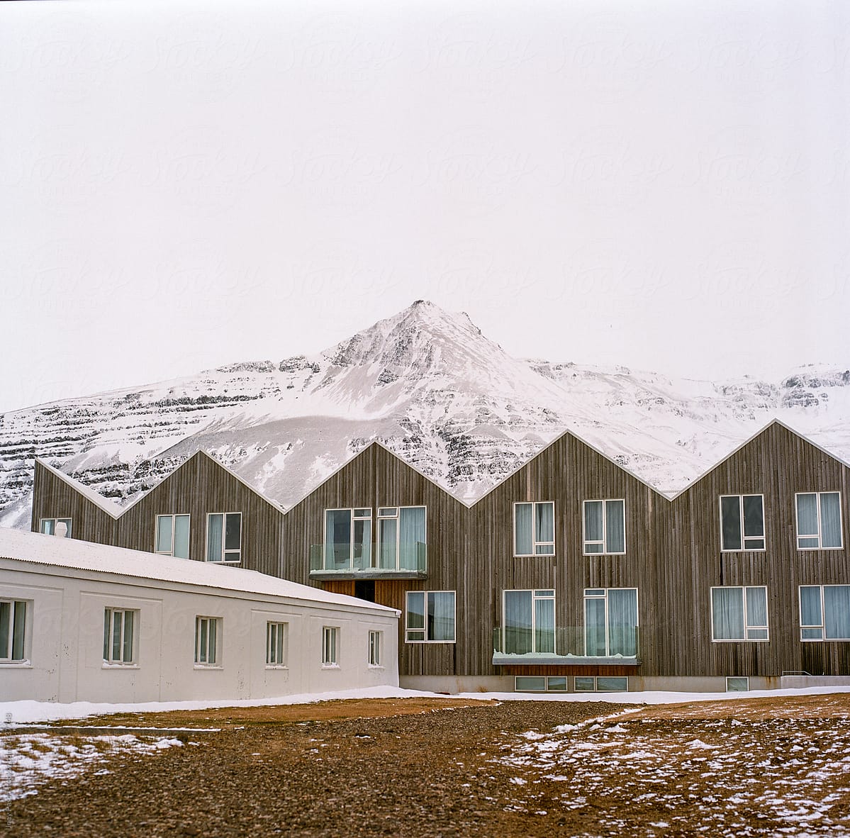 A hotel in Iceland stands before a glacier the day after a blizzard.