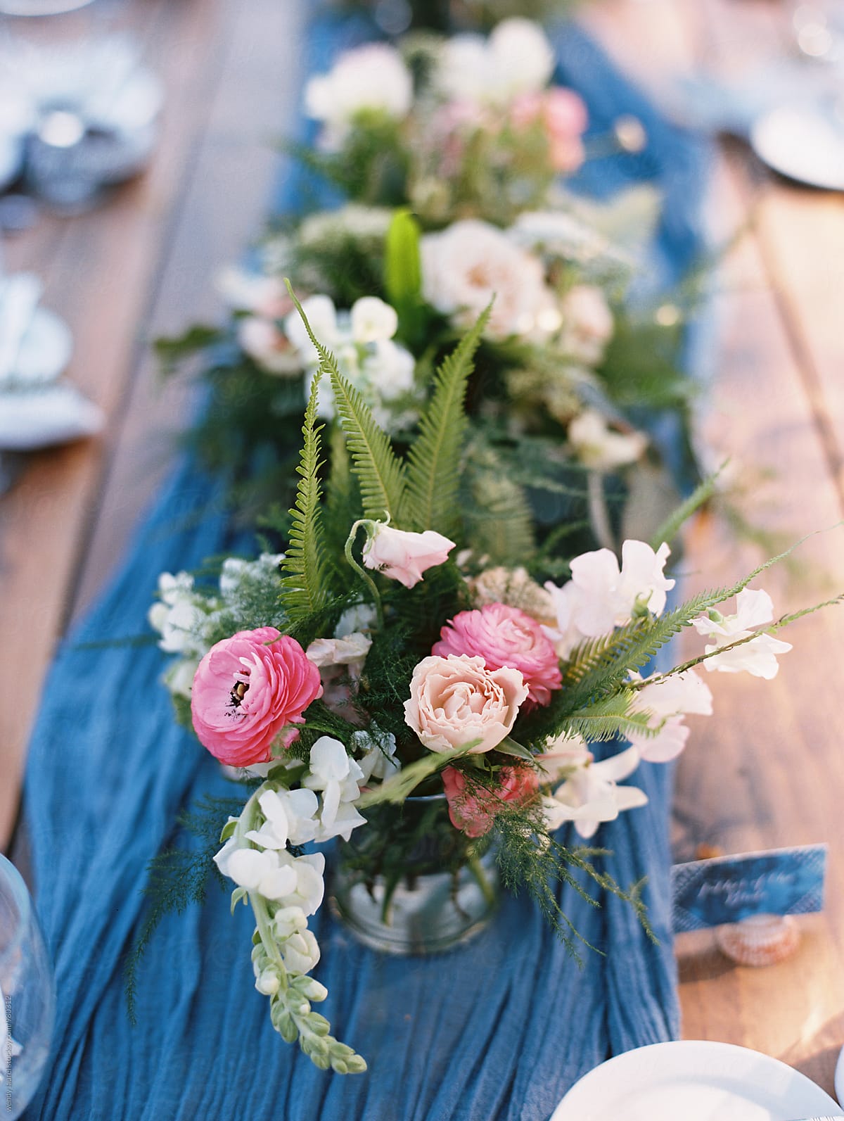 blue runner on table with pink floral centerpiece