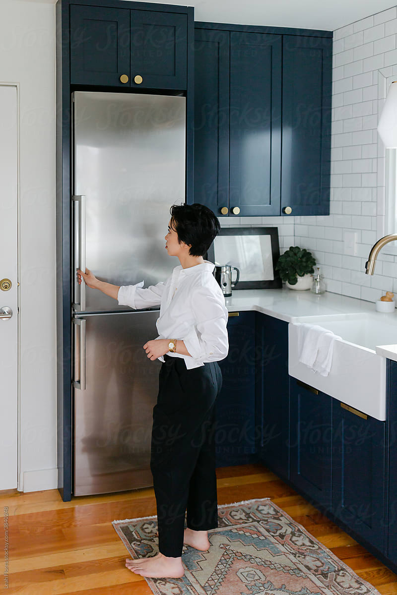 Asian Woman Opening Refrigerator in Kitchen
