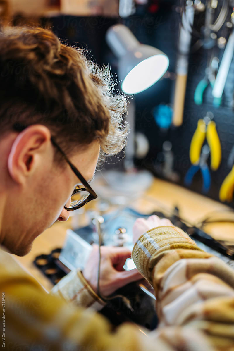 Repairman troubleshooting amplifier in repair shop