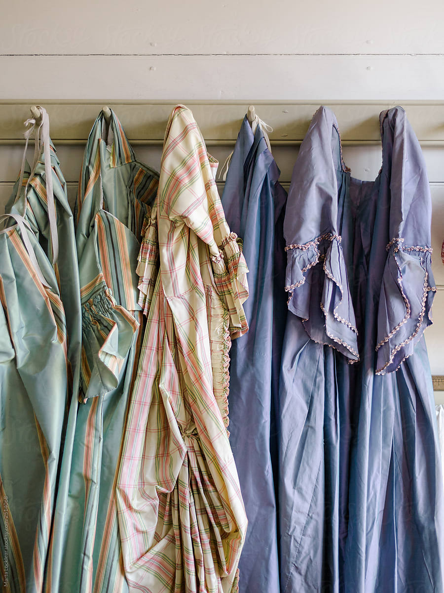 Historic colonial gowns hanging on a peg board