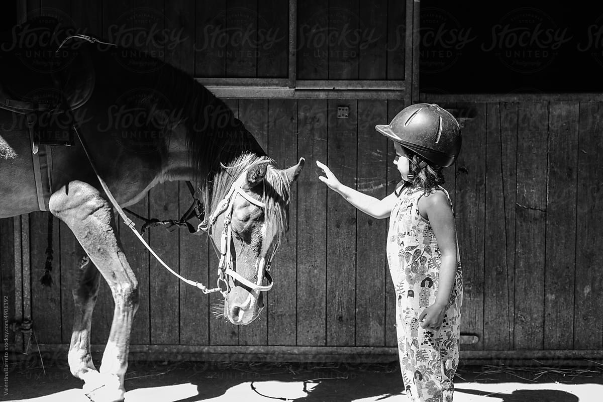 young girl touching horse