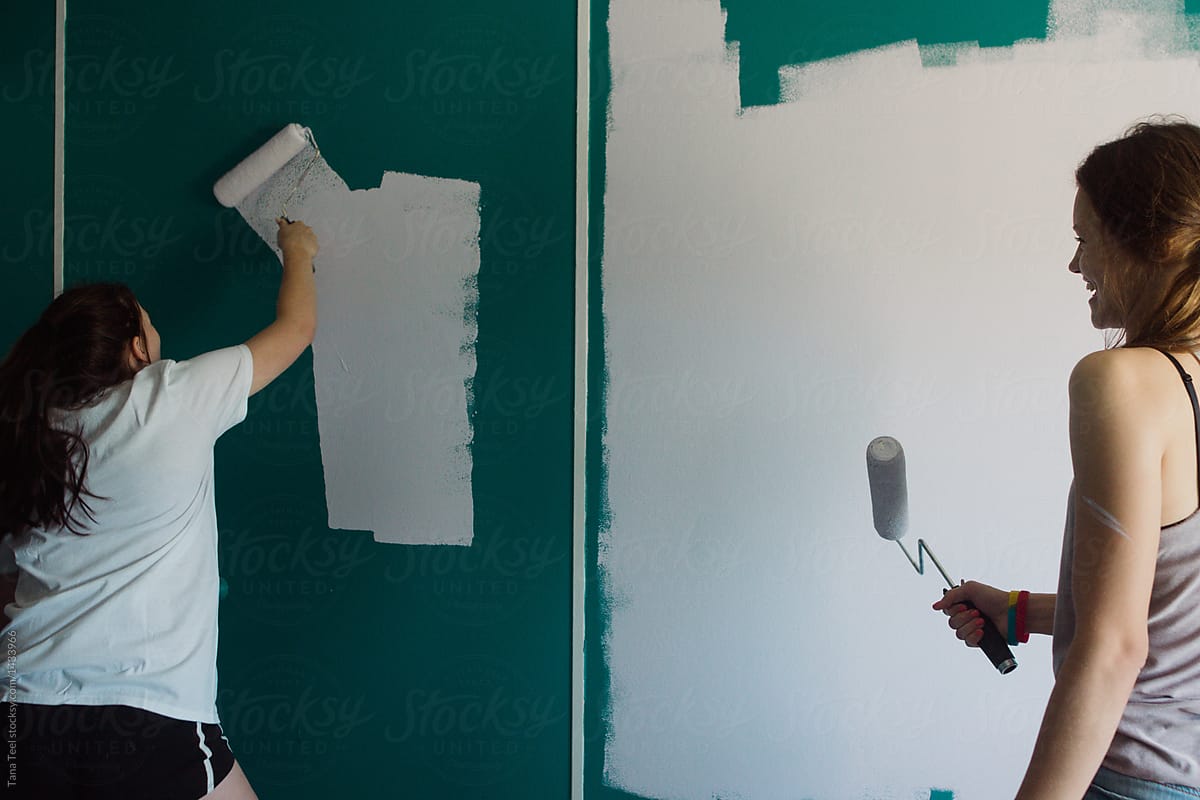 teenagers painting walls in a room