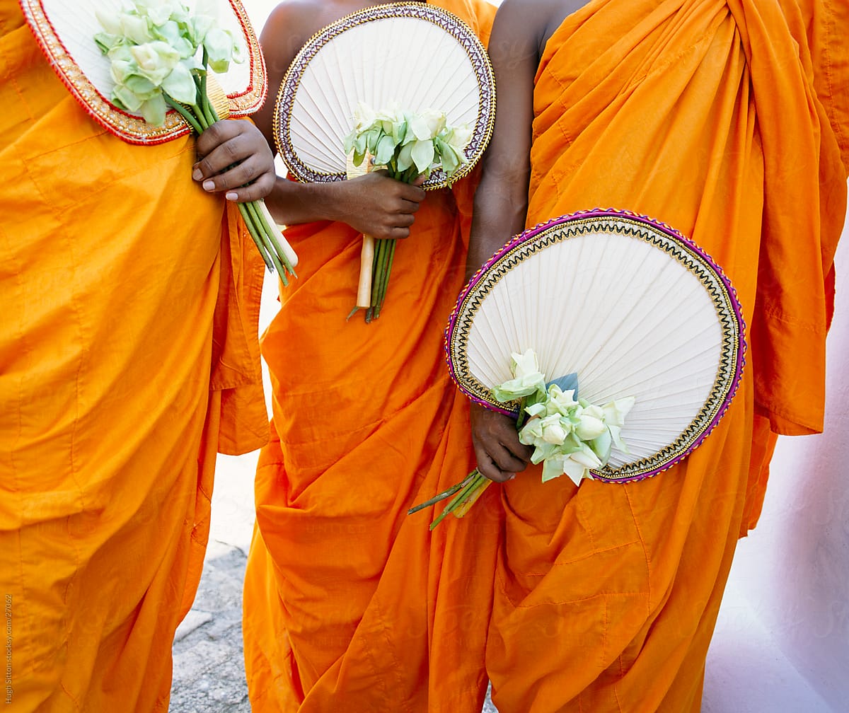 buddhist monks holding lotus flowers