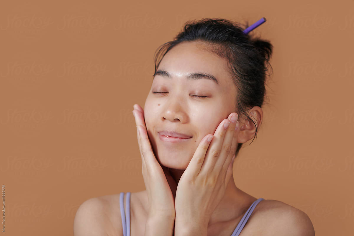 Woman putting her hand at her face and posing while close eyes