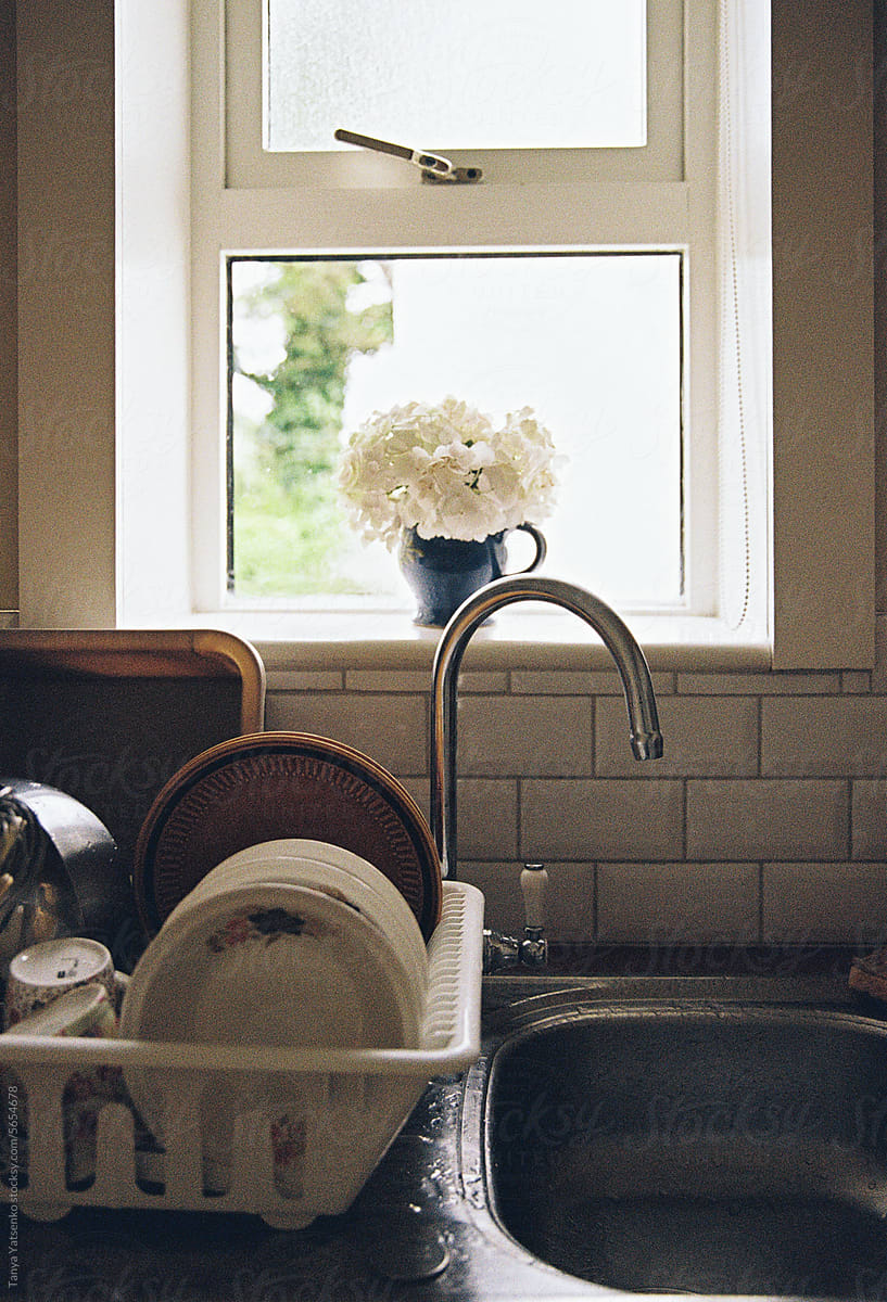 A kitchen sink with plates and dishes