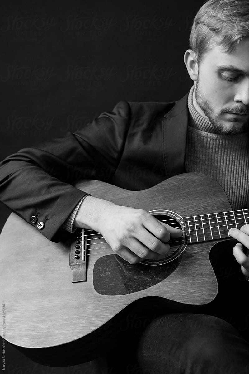 black and white portrait of stylish musician guy playing guitar