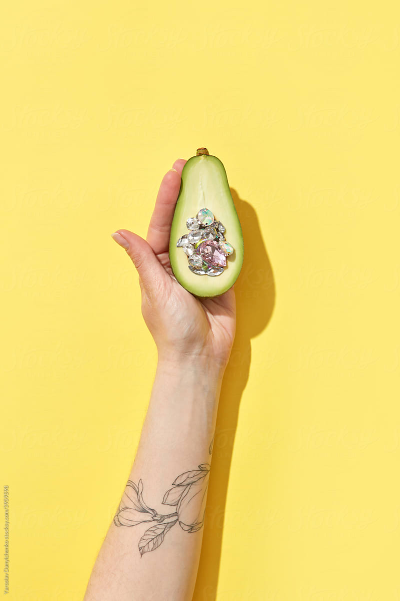 Woman holding avocado with diamonds