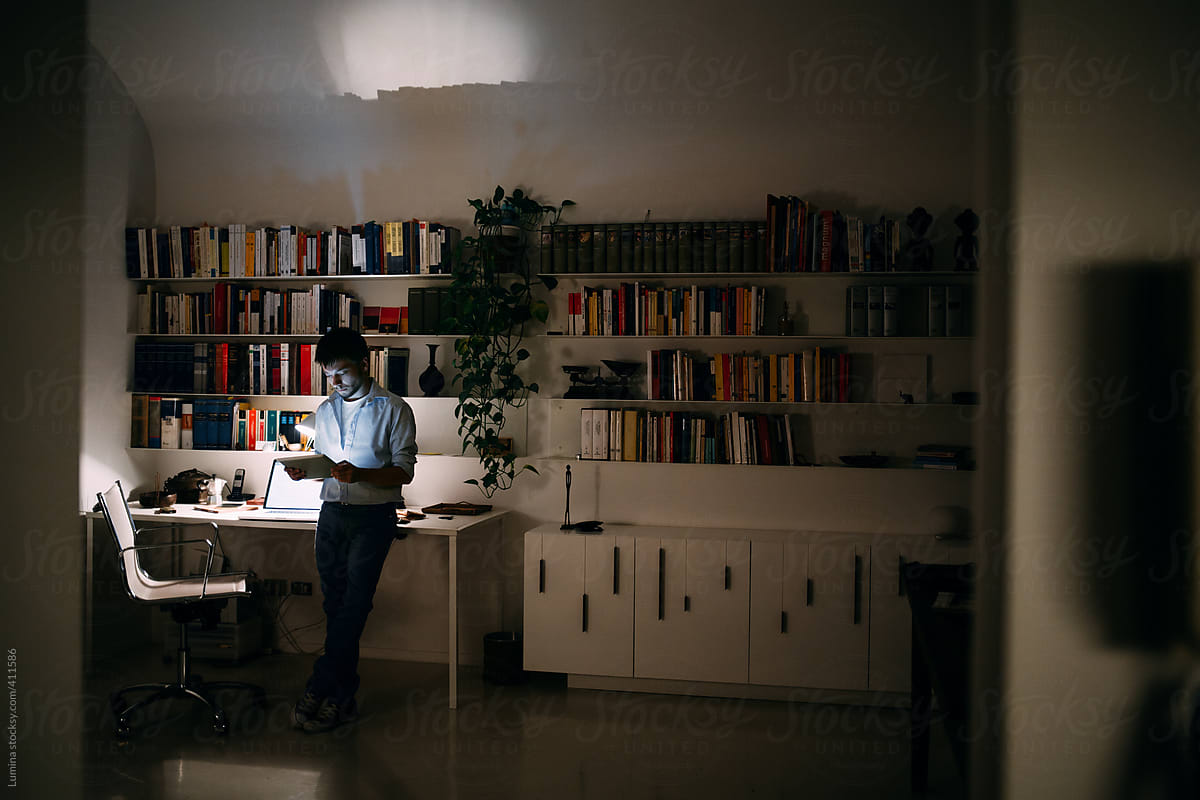 Caucasian Man Using a Tablet at His Office at Night