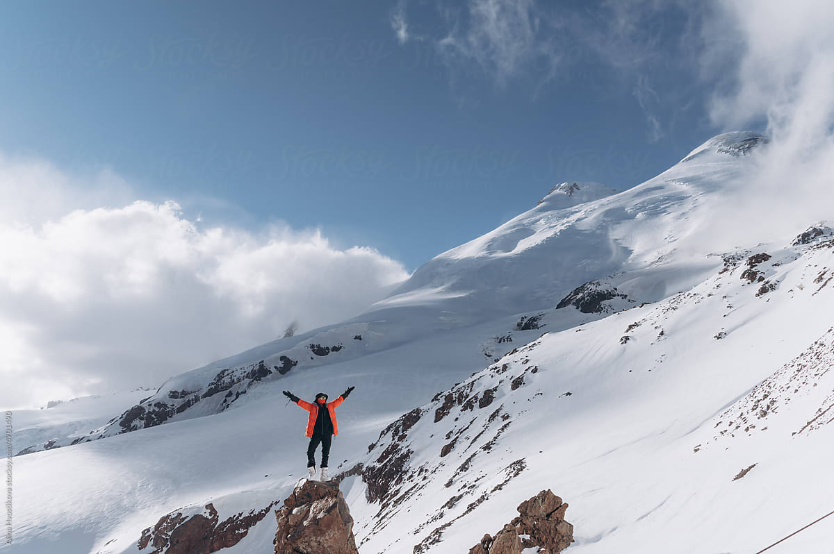 Anonymous hiker standing on snowy mountain slope