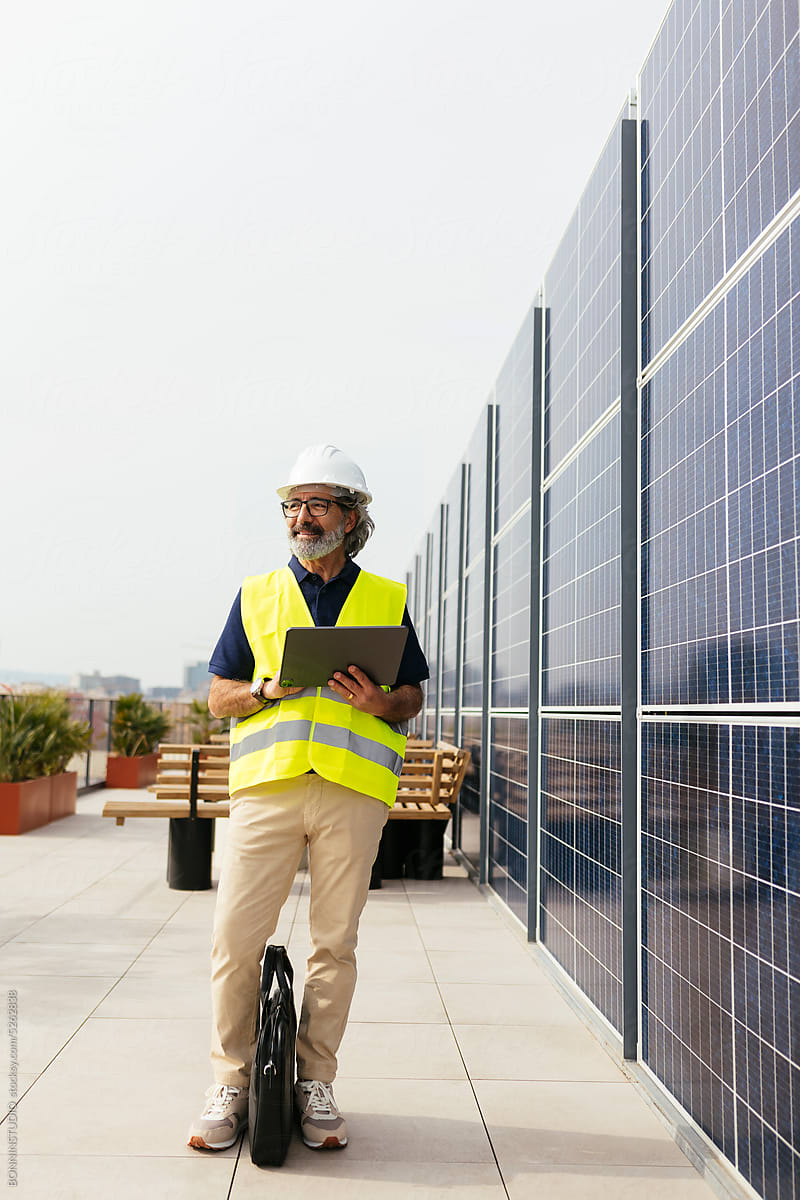 Male engineer with digital tablet near solar panels