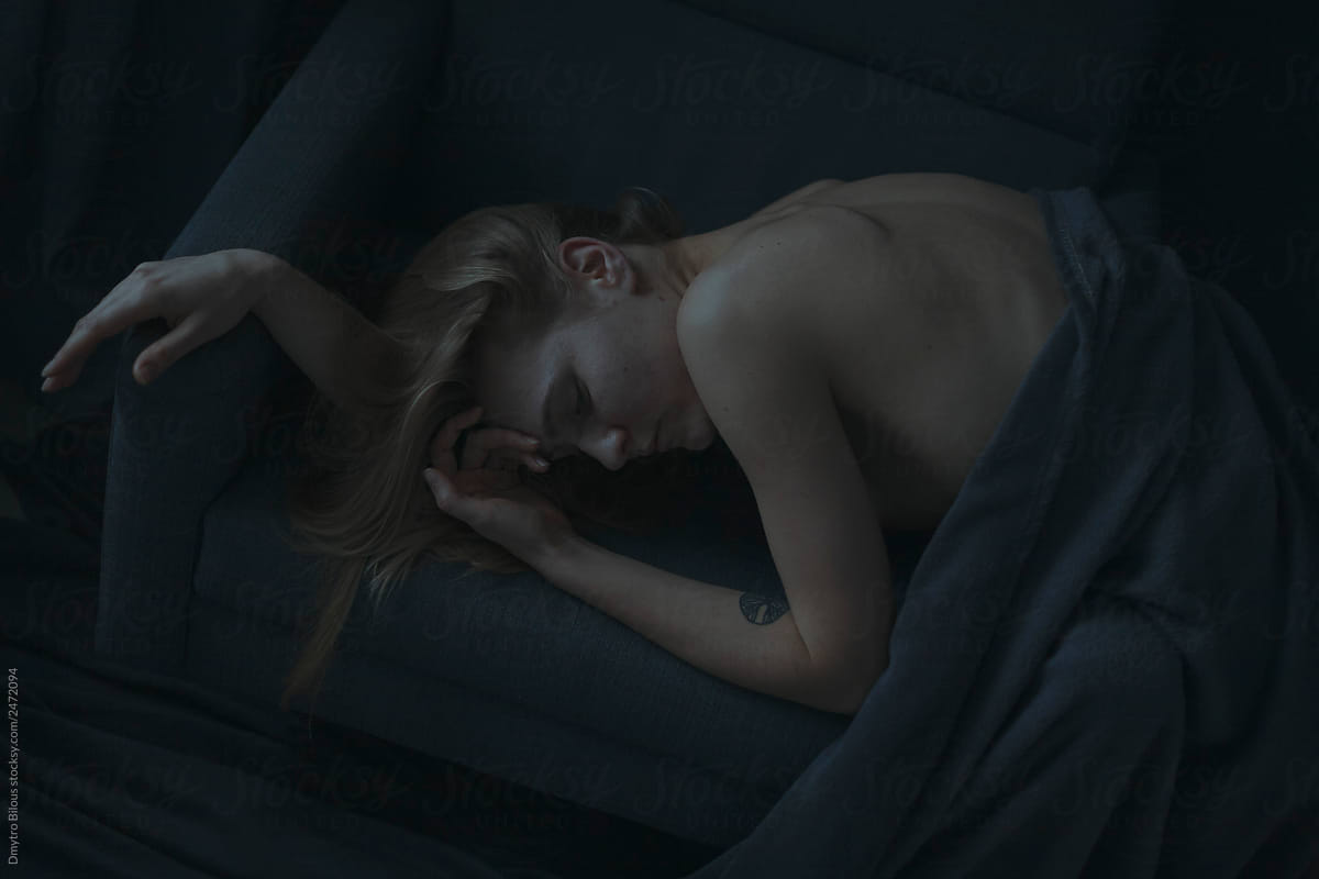 woman sleeping on a dark couch. covered with a veil
