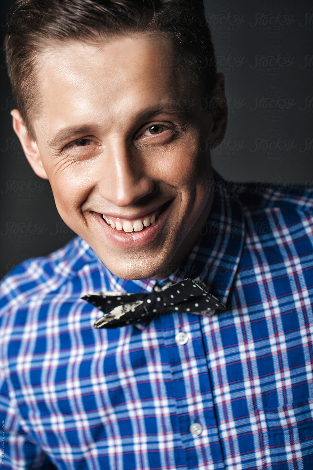 Smiling stylish handsome man in bow tie in studio