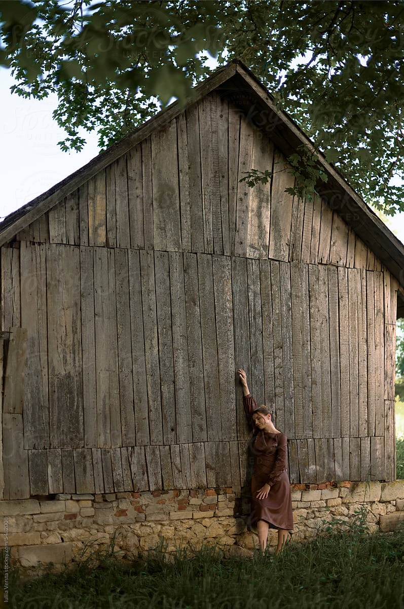 young woman near an old wooden house