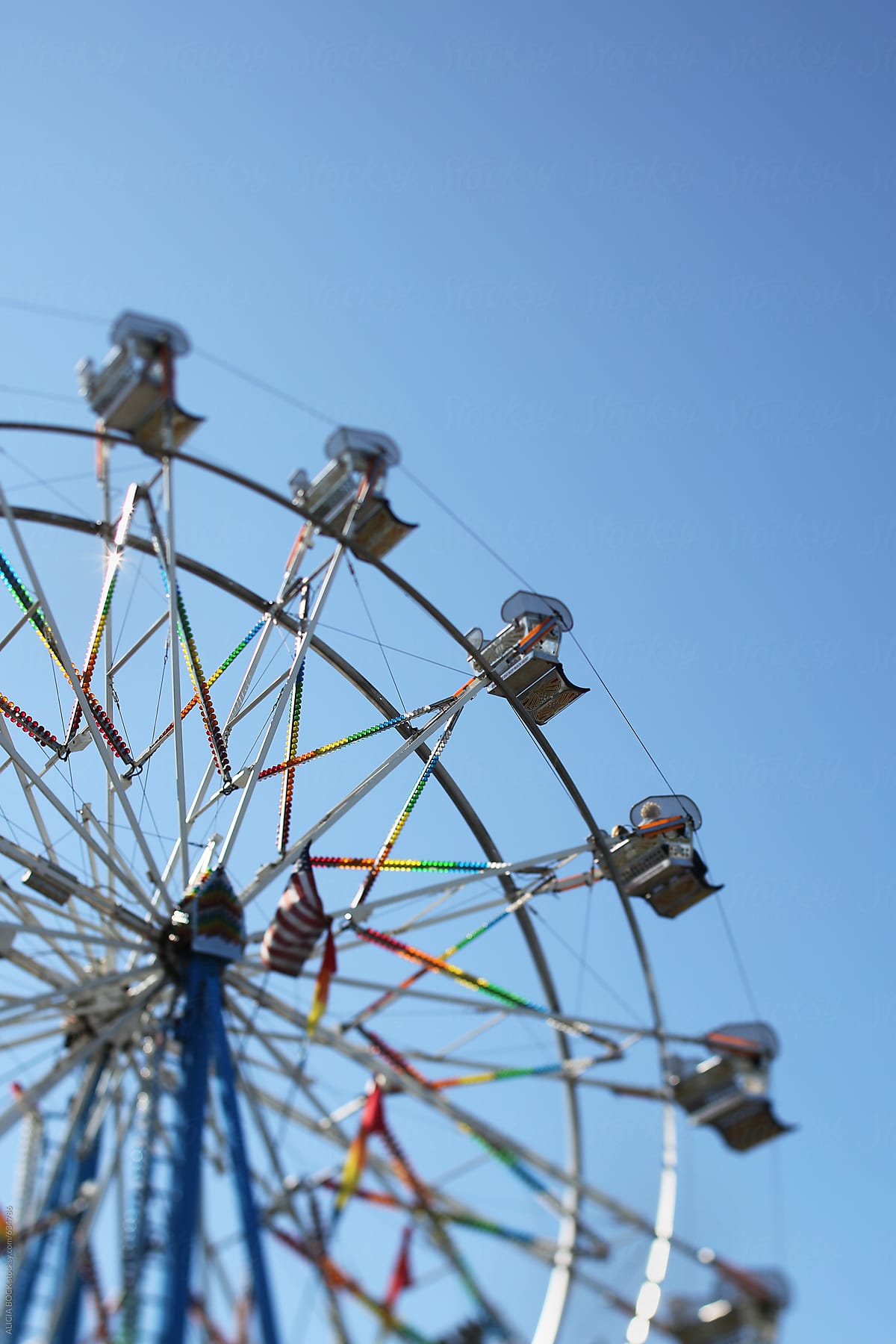 A Large Metal Ferris Wheel At A Summer Carnival