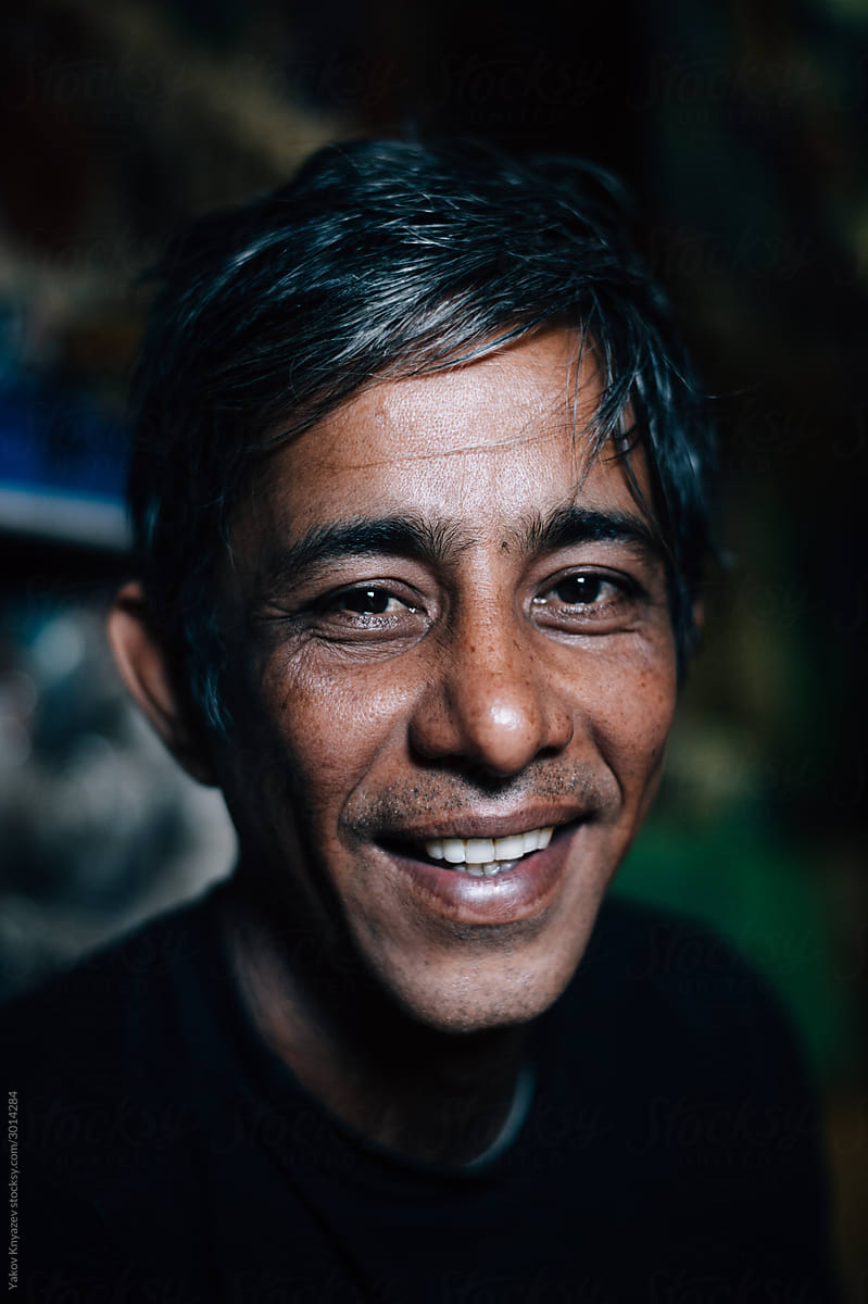 portrait of a laughing Tibetan man in his shop