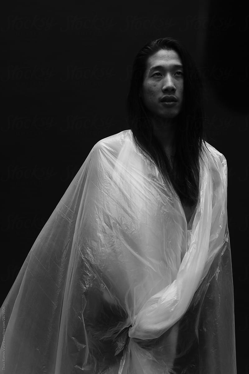 asian long haired man, dressed in plastic.