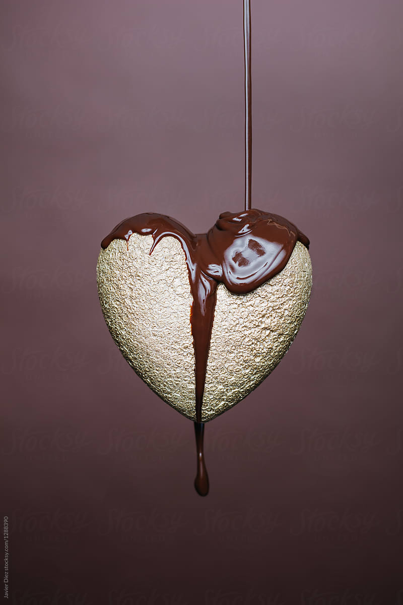 Gold heart being covered with chocolate