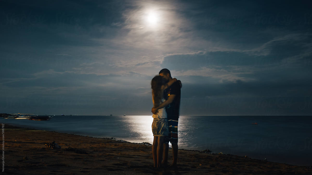 Romantic Couple Kissing Under The Full Moon Stocksy United