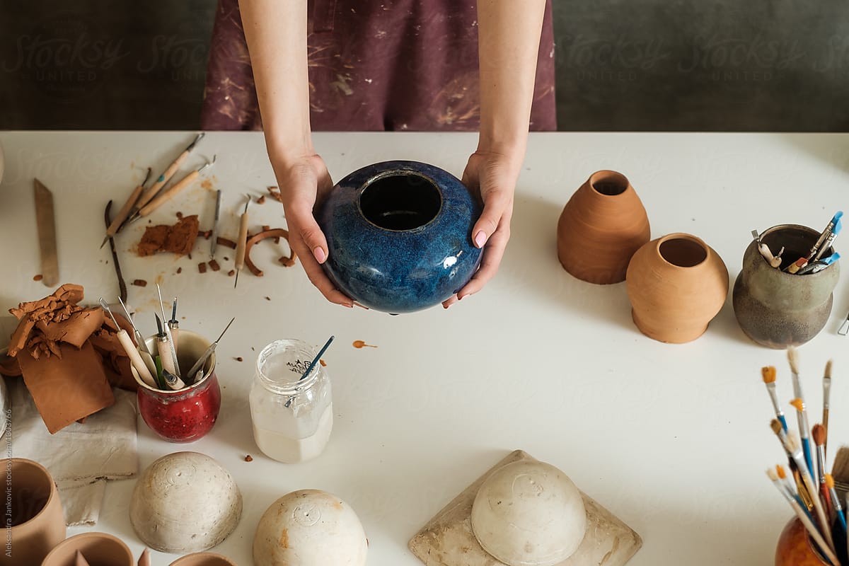 Anonymous Female Artisan Holding Blue Ceramic Vase In The Pottery Studio