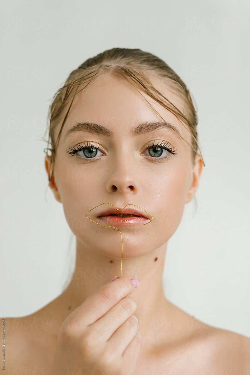 Closeup Portrait Of A Cute Blond Girl With Big Blue Eyes Starring At