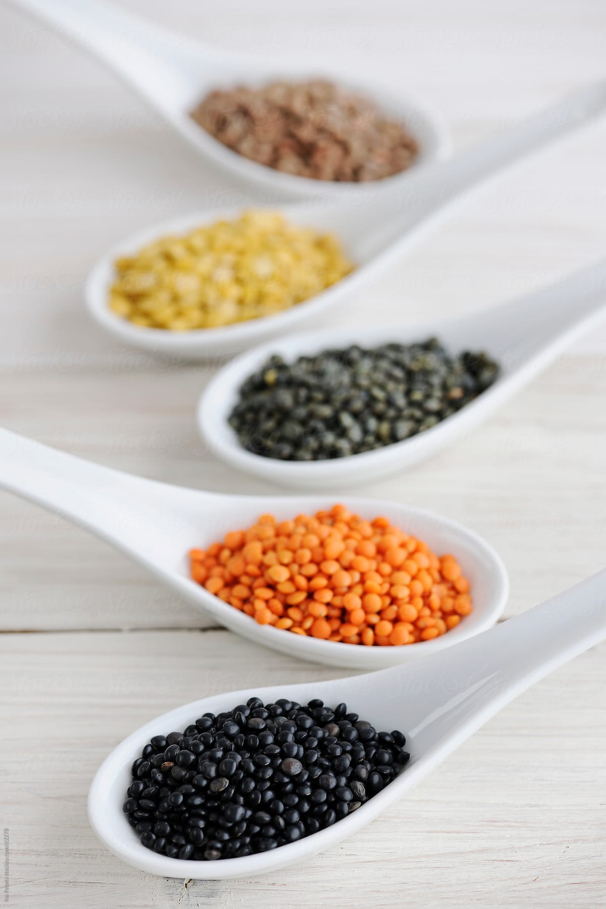 Food: Different sorts of Lentils in White Spoons