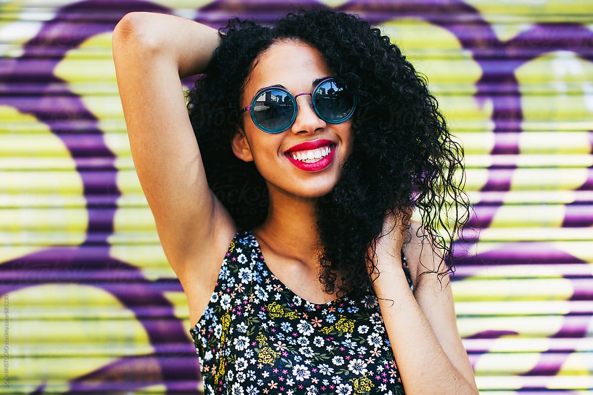 Portrait Of A Smiling Woman Wearing Sunglasses Standing On The Street