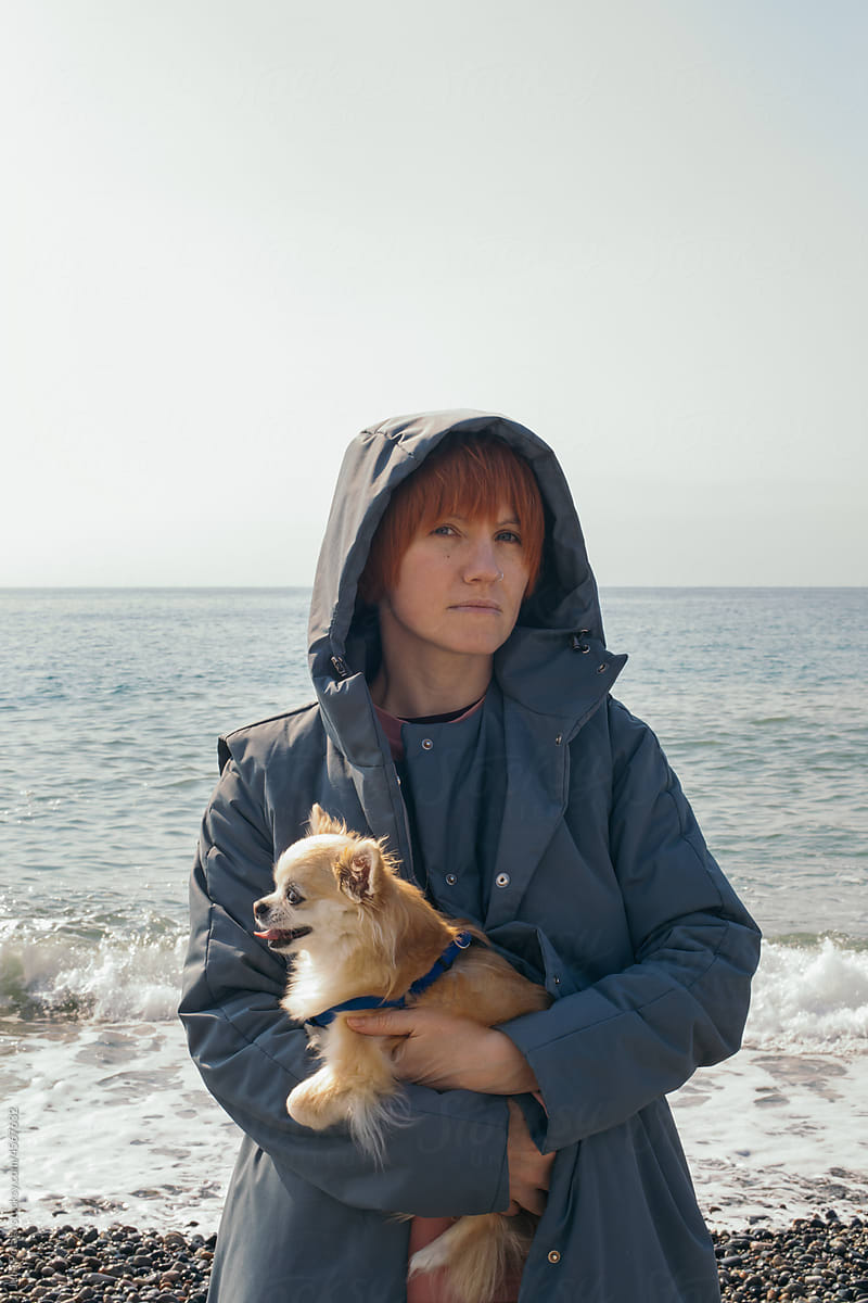 A girl stays with a dog on the sea beach