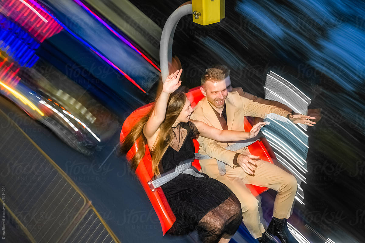 Enthusiastic happy couple in love in the evening at the attraction