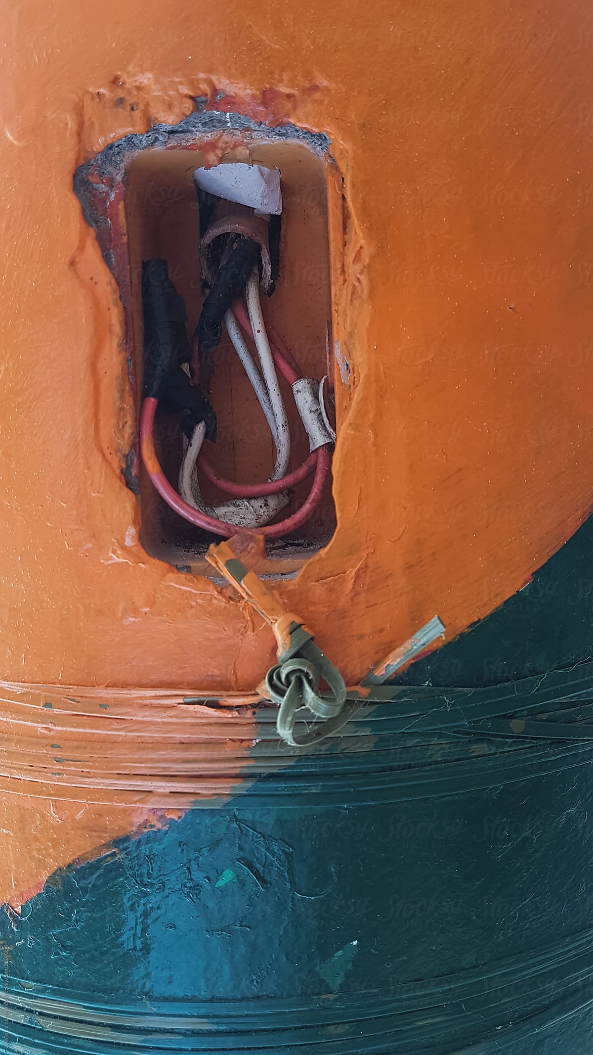 Damaged power outlet on a wall painted with bright colors.
