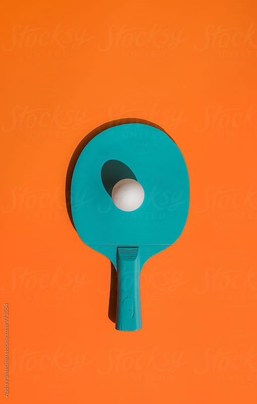 Blue ping pong racket with ball.