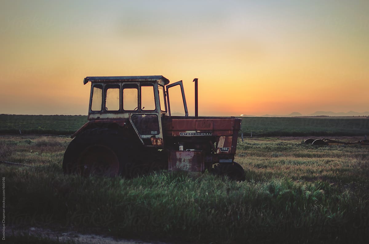 Old tractor against setting sun