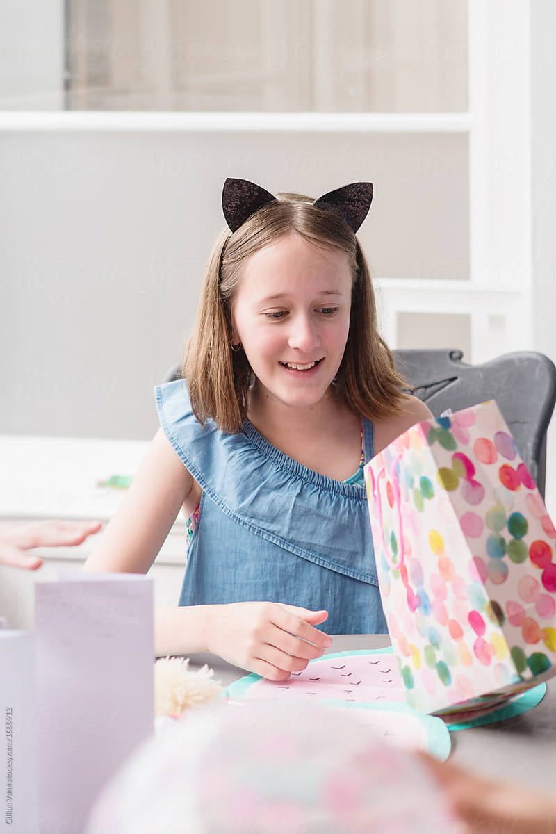 Tween Girl Opening Presents At Her Birthday Party By Stocksy