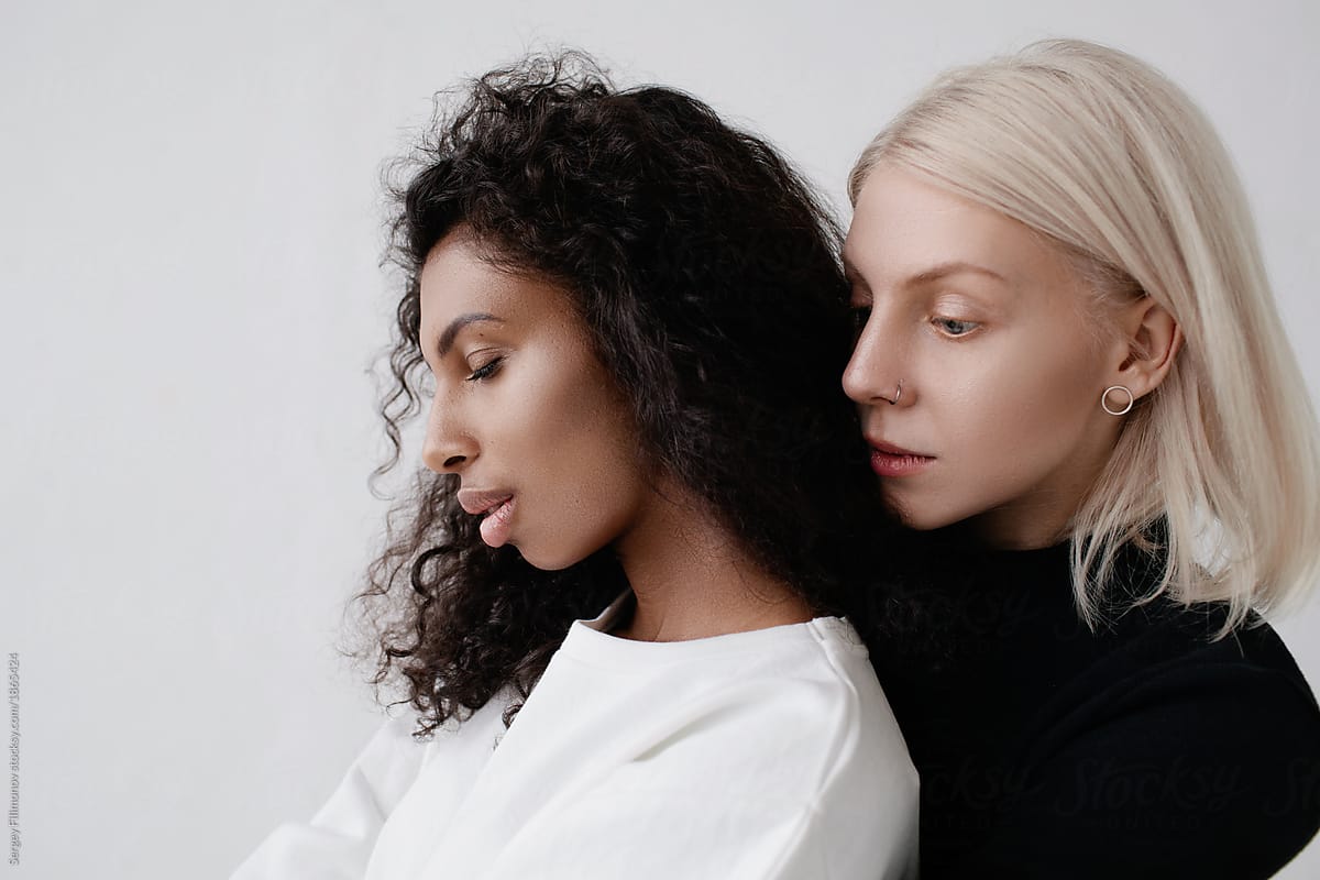 Portrait of two fashionable women in white studio