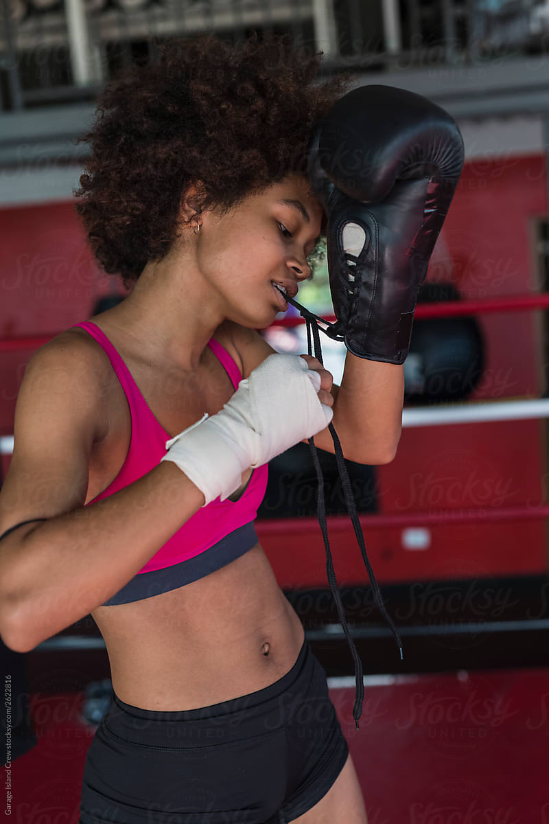 black woman boxer putting hes gloves on.