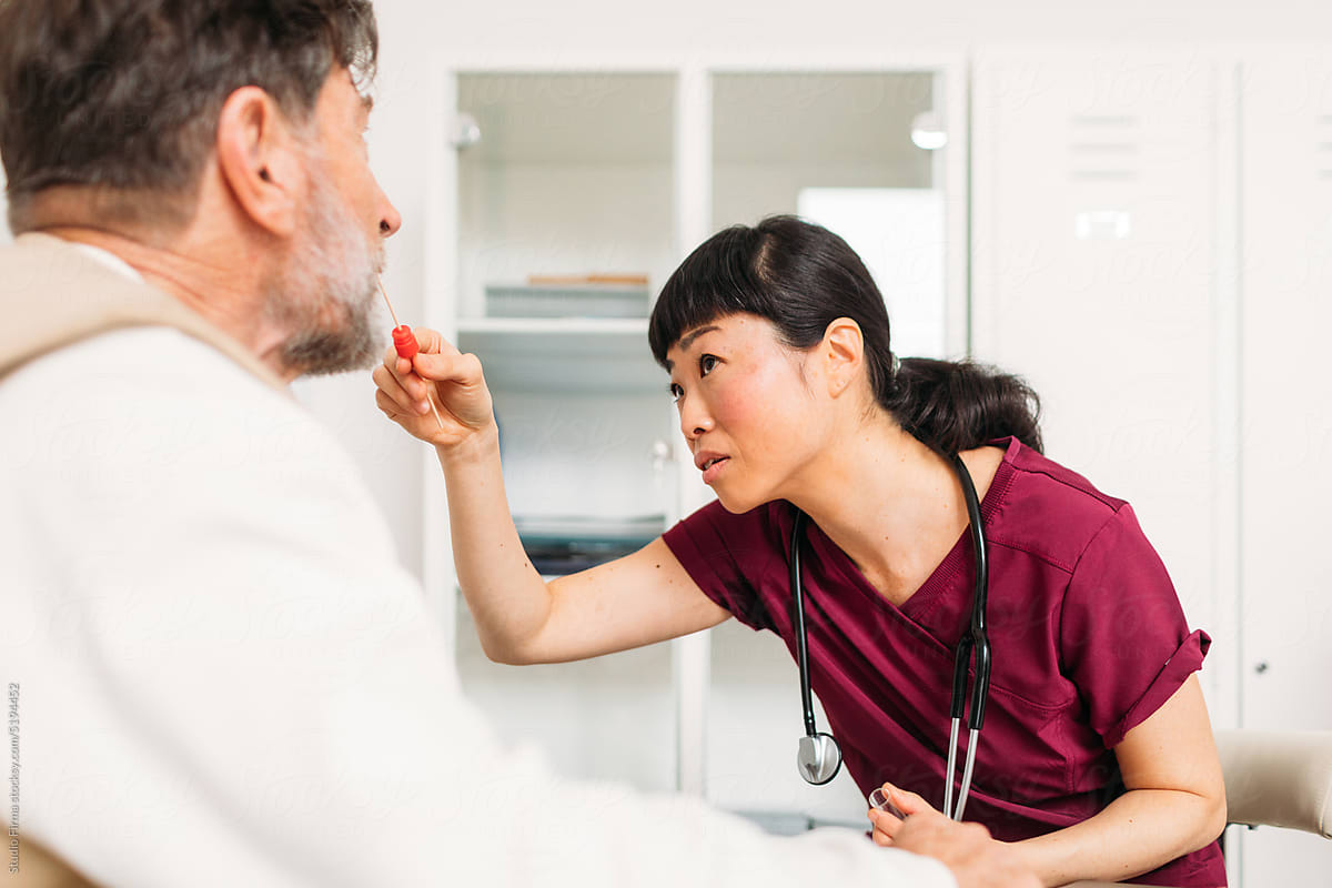 Female Physician Examining Man\'s Throat