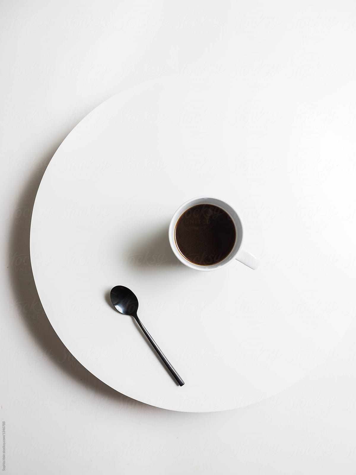 Black coffee on white table with black spoon