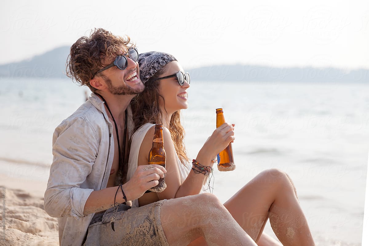 Couple Enjoying Their Holiday Drinking Beer At The Beach By Jovo Jovanovic 