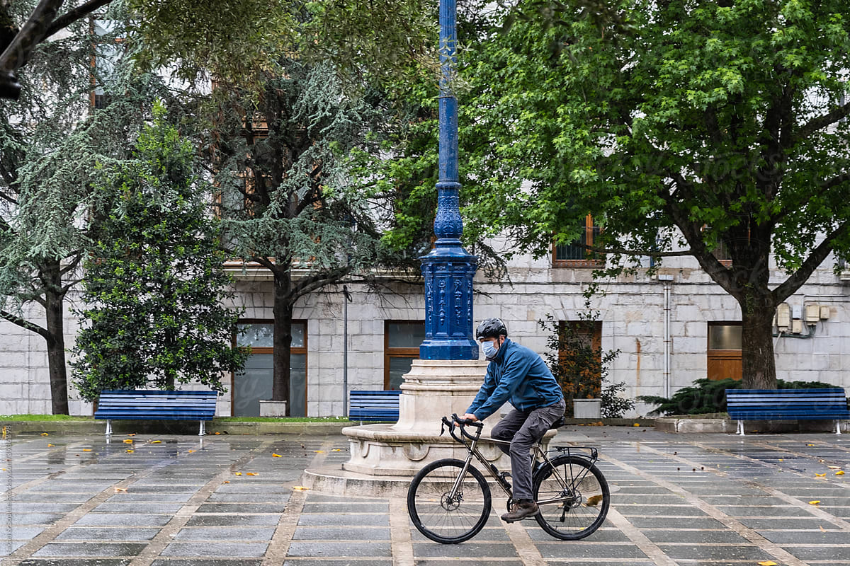 masked man on bike in a city