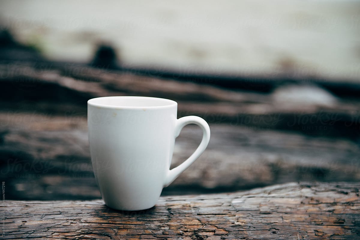 coffee mug placed on sea driftwood