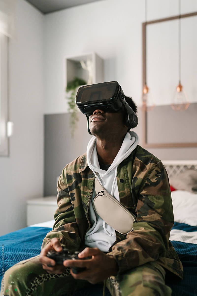 African American gamer in VR goggles looking up