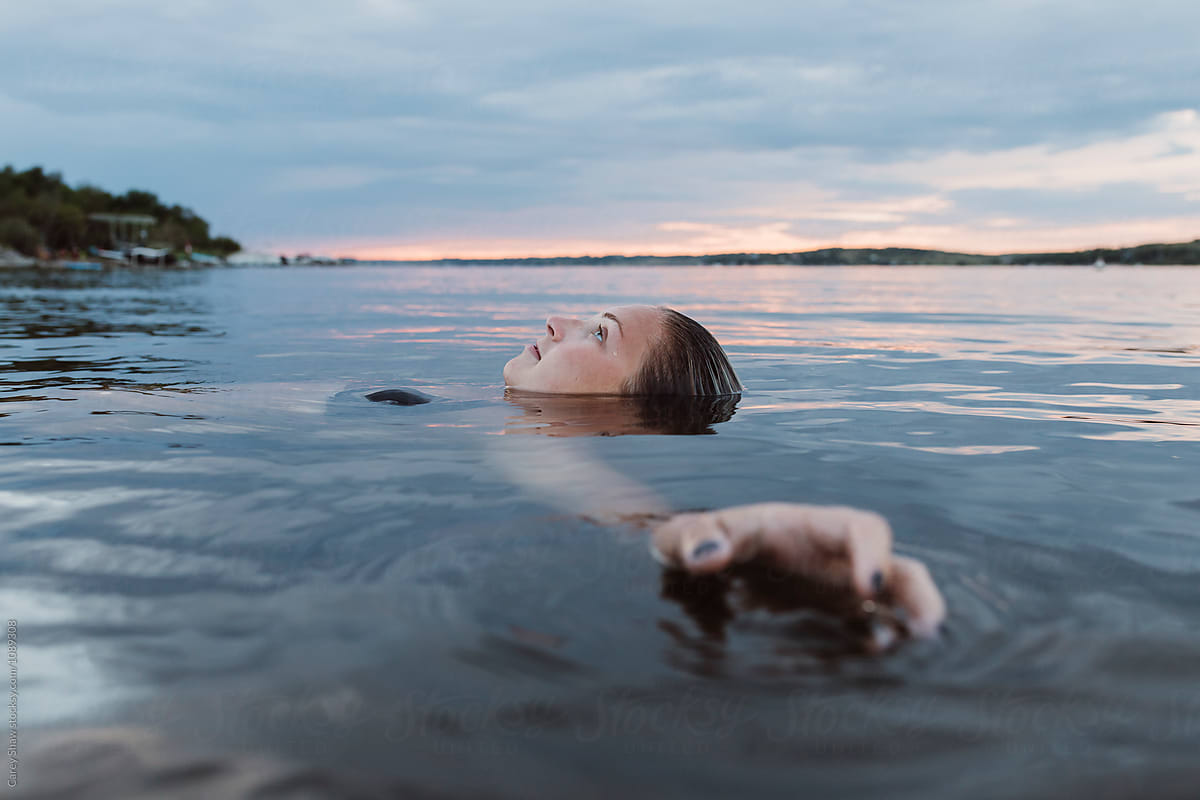 Beautiful Woman Floating In Calm Water At Sunset By Stocksy Contributor Carey Shaw Stocksy