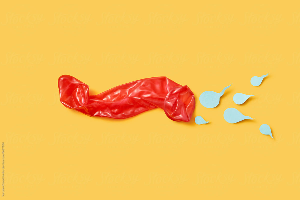 Used red condom and paper sperm on yellow background.