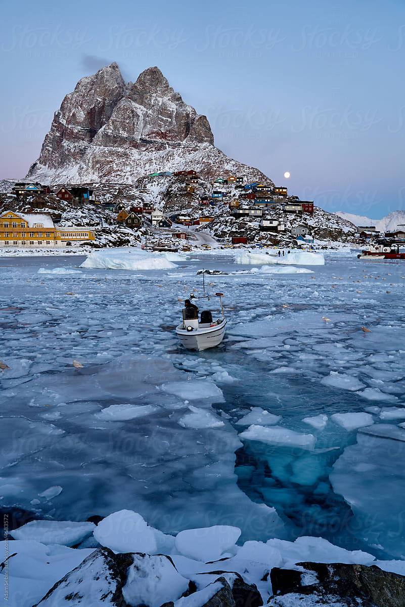 Fishermen in Uummannaq harbor, Greenland Arctic, sea ice and boats